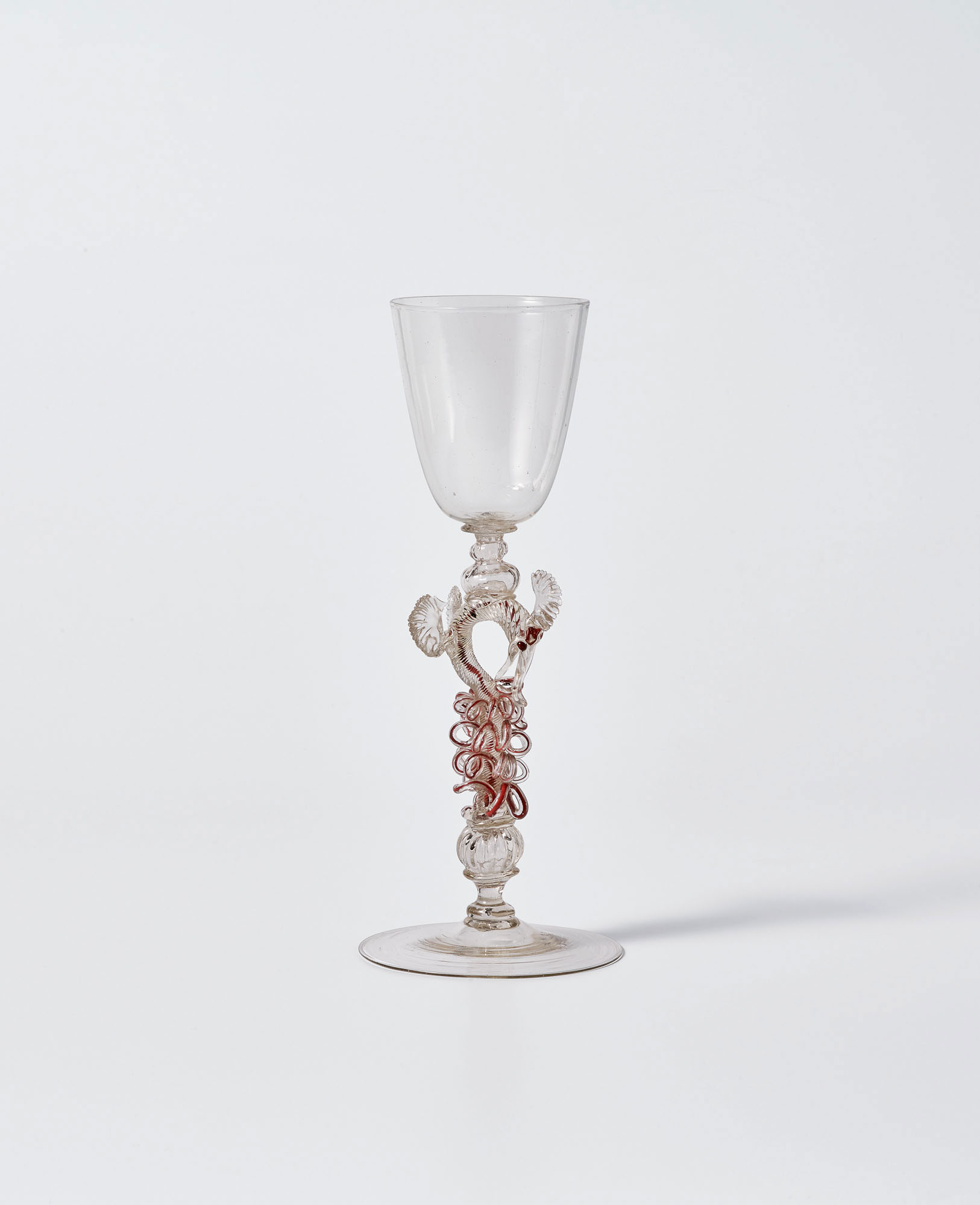 Colorless glass goblet with decorative stem featuring red cane twisted to resemble a crouching dragon