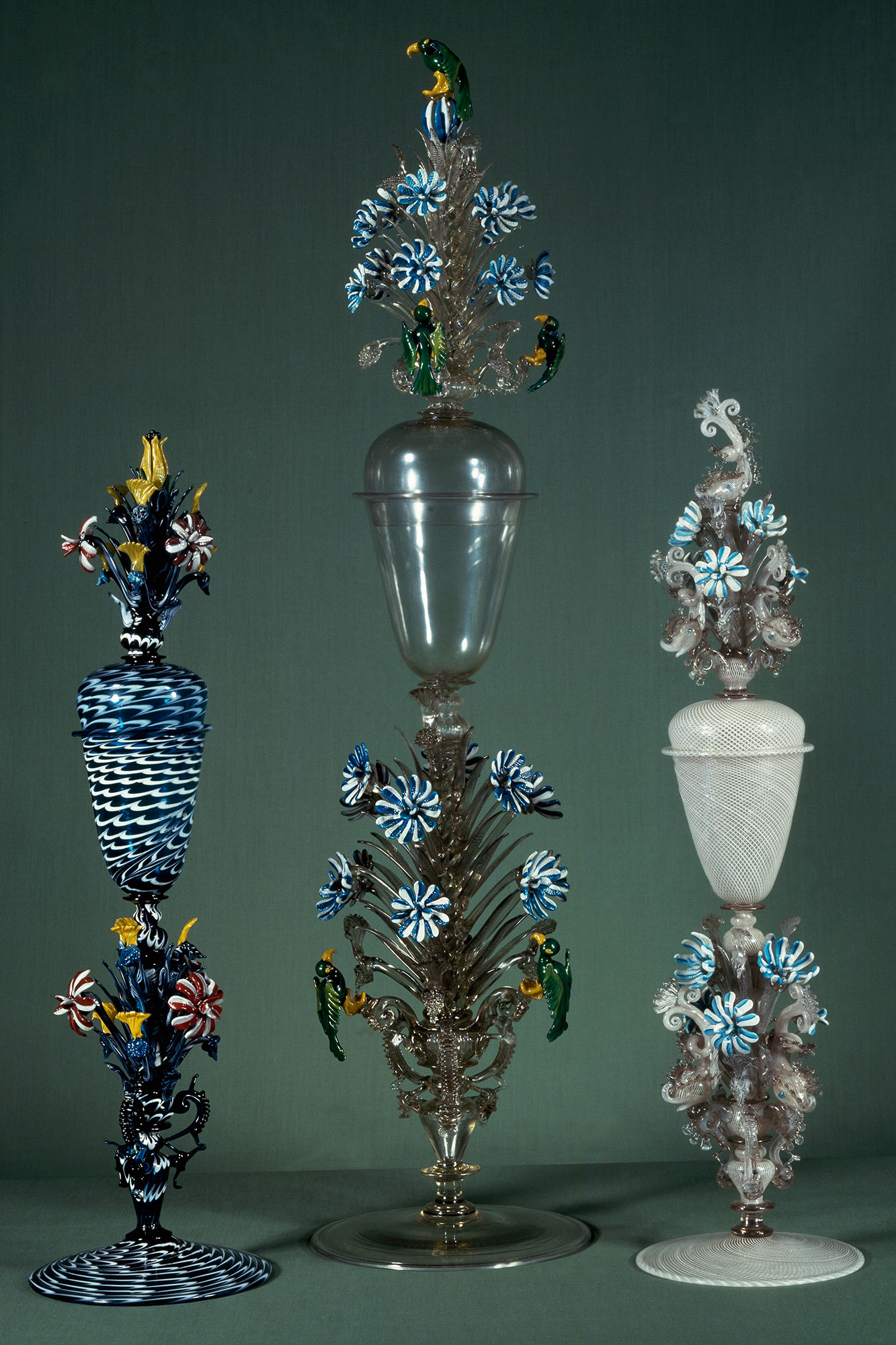 Three glass goblets elaborately decorated with blue and white stripes and flowers
