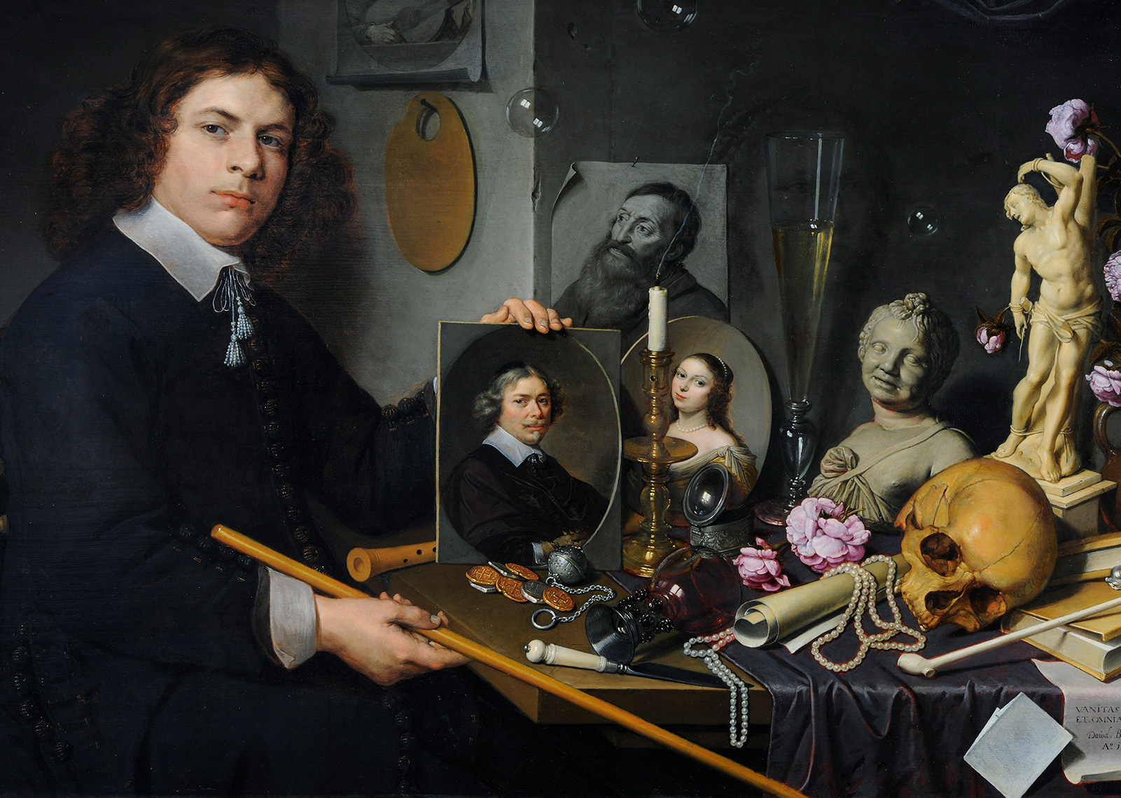 Painting of artist seated at table covered with portraits, sculpture, books, and various tools