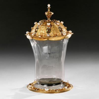 Clear glass vessel with gold trim at base and gold, jewelled lid.